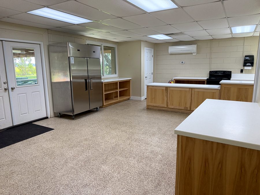 The other end of the kitchen, showing a full-size stainless refrigerator-freezer and an exterior door